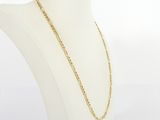 a gold chain necklace on a mannequin torso