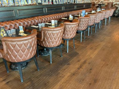 de nombreux fauteuils en cuir marron au comptoir d'un restaurant