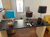 un bureau sur lequel se trouvent une lampe, un abat-jour et d'autres objets