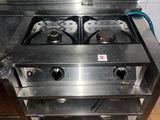 une cuisinière en acier inoxydable à deux feux dans une cuisine
