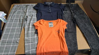 three pairs of jeans and a t - shirt are sitting on a table