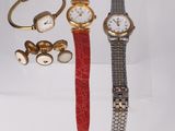 three watches and a cuff watch on display in a clear box