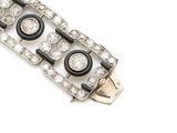 a close up of a silver and black bracelet on a white background