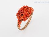 an image of a ring with orange coral stones on it