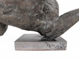 a statue of an elephant that is laying down on a block