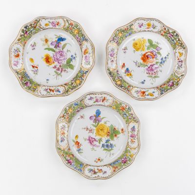 trois assiettes ornées de motifs floraux et d'une bordure dorée