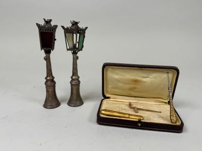 pair of antique brass candlesticks and a pen in a case
