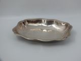 a silver plate with a wavy edge on a white surface