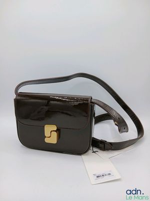 un sac à main noir orné d'une boucle dorée sur le devant