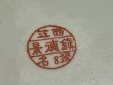 a white plate with a red design on it