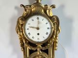 a gold clock hanging on the wall with a crown on top
