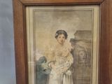 tableau représentant une femme tenant un bébé dans ses bras, dans un cadre en bois