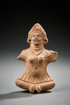 une petite figurine en argile représentant une femme coiffée d'un chapeau