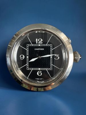 a silver clock with a black face on a blue background