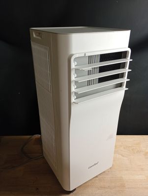 un climatiseur blanc posé sur une table en bois