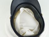 a black hat on a white plate on a white surface