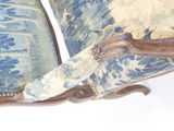 a close up of a chair with a blue and white upholstered cushion