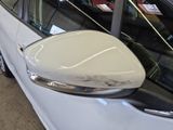 a white car that has a mirror on the side of it