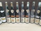 several bottles of wine are lined up on a wooden table