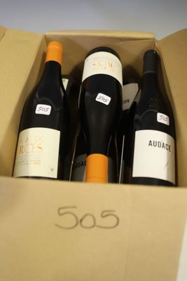 three bottles of wine in a cardboard box on a table