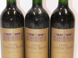 trois bouteilles de vin posées sur une table blanche
