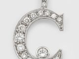 a close up of a diamond letter c pendant on a white background