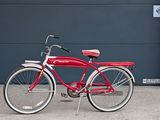 a red bike parked in front of a garage door