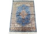 une image représentant un tapis bleu et beige sur fond blanc