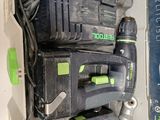 une perceuse à fil noir et vert et deux autres outils dans une boîte
