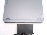 a laptop computer sitting on a white surface with a power cord