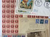 quelques vieux timbres et cartes postales sont posés sur une table