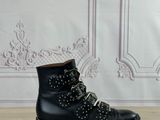 des bottines noires cloutées posées sur une surface en bois