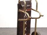 a small hand truck with luggage on it on the floor