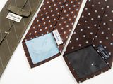 three ties with a tag on them sitting next to each other