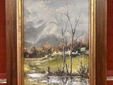 une peinture à l'huile d'un paysage dans un cadre en bois sur un tapis rouge
