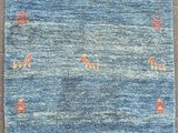 a blue rug with orange and white designs on it