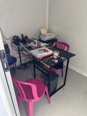 une chaise rose placée devant un bureau sur lequel se trouve un ordinateur