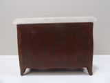 a small wooden box with a marble top on a white table