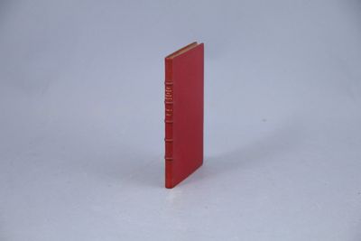 un livre rouge posé sur une surface blanche