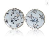 two blue and white plates with floral designs on them on a white surface