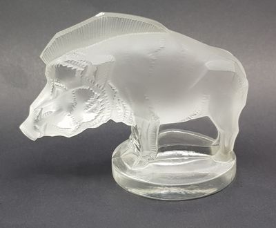 a clear glass figurine of a bull on a base