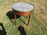 une petite table avec un plateau en marbre posée dans l'herbe