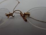 a pair of glasses sitting on a table with a chain around them