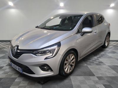 une voiture argentée est garée sur le sol à carreaux d'un garage