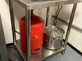 a red gas can sitting on a stainless steel shelf