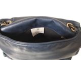 the inside of a blue purse with a gold chain around it