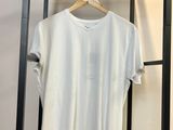 Le t-shirt blanc est suspendu à un portant dans une pièce.