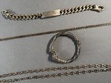trois types de chaînes différents et un bracelet posés sur une table