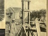 an old photo of a man standing next to a machine