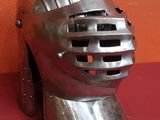 un casque argenté sur un fond rouge, avec un mur en arrière-plan